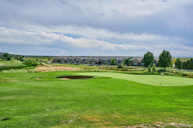 view of home's community with a putting green, view of golf course, and a lawn