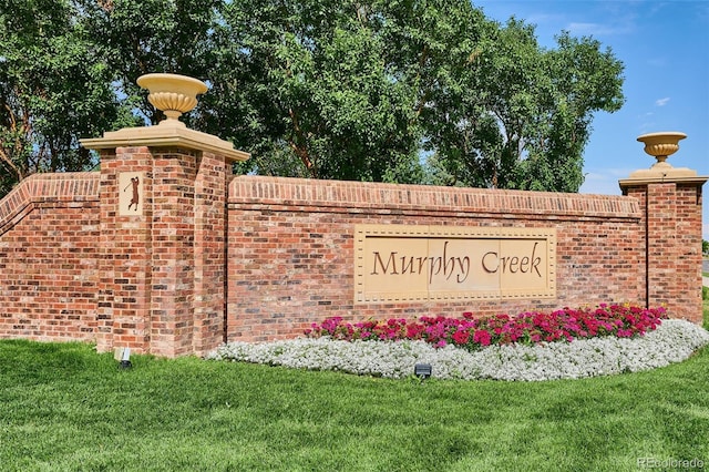 community / neighborhood sign with a yard