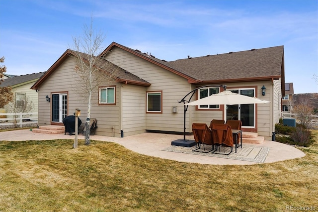 rear view of house with fence, central AC, a lawn, french doors, and a patio