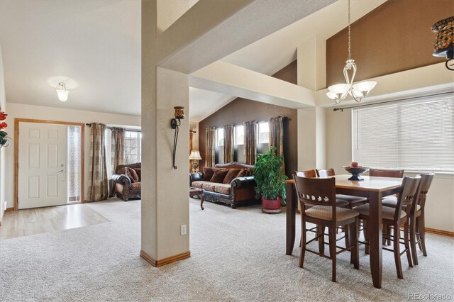 dining area featuring baseboards, high vaulted ceiling, a chandelier, and carpet flooring