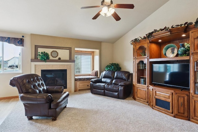 carpeted living room with lofted ceiling, a fireplace, and ceiling fan