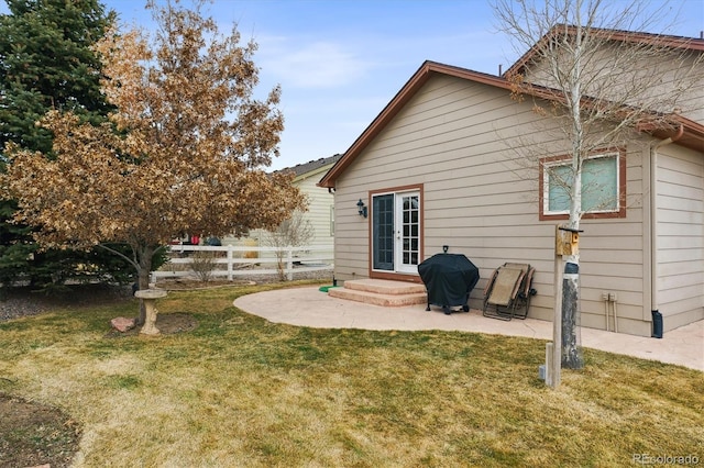 rear view of house with a patio area, a lawn, french doors, and fence