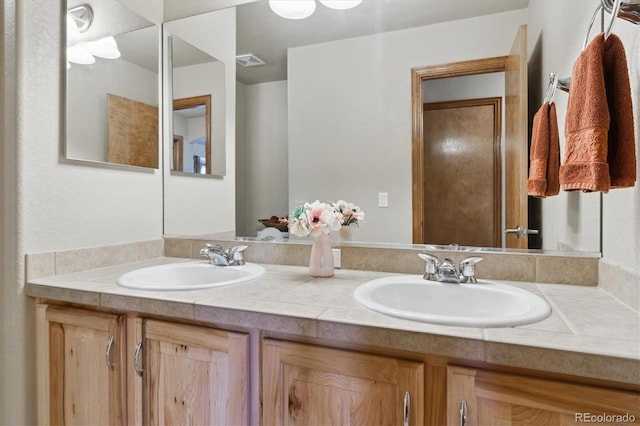 full bath featuring a sink, visible vents, and double vanity