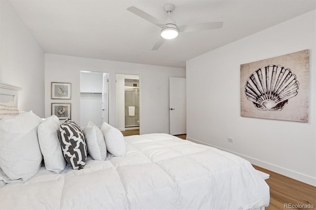 bedroom featuring ensuite bath, ceiling fan, wood-type flooring, a spacious closet, and a closet