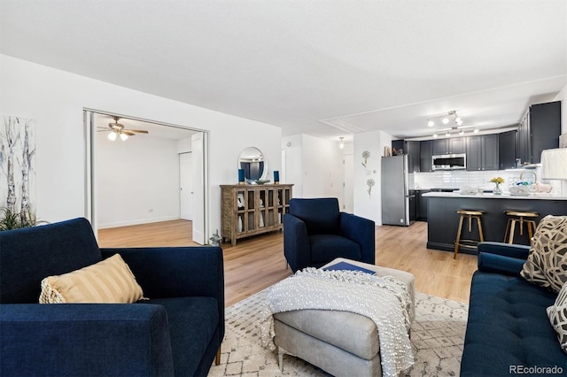 living room with ceiling fan and light hardwood / wood-style floors