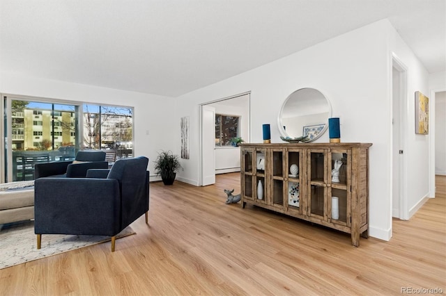 living room with light hardwood / wood-style flooring and a baseboard heating unit