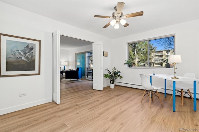 office area featuring light wood-type flooring, baseboard heating, and ceiling fan