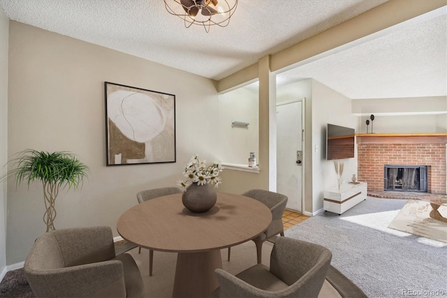 dining area featuring light carpet, a textured ceiling, and a brick fireplace