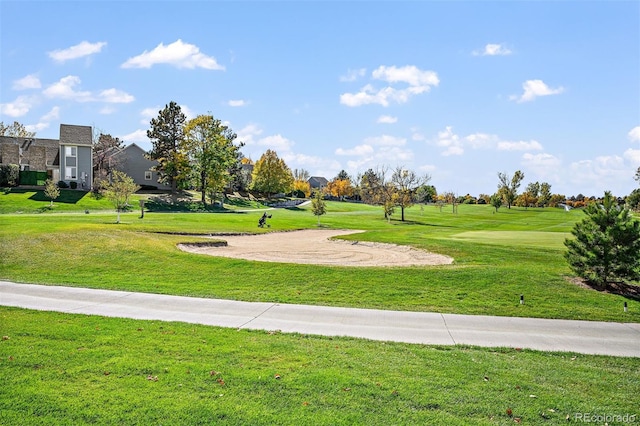 view of home's community featuring view of golf course and a lawn