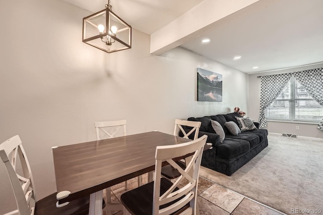 dining space with carpet and a notable chandelier