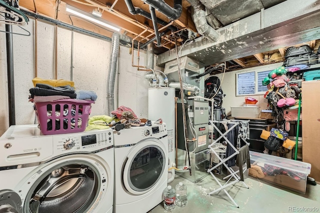 clothes washing area featuring washing machine and dryer and water heater