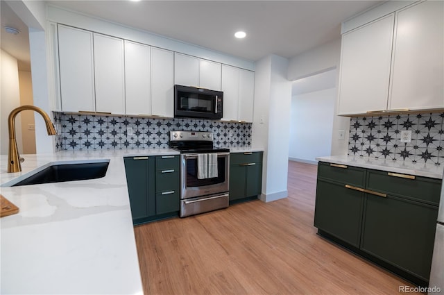 kitchen featuring decorative backsplash, sink, white cabinetry, and stainless steel range with electric cooktop