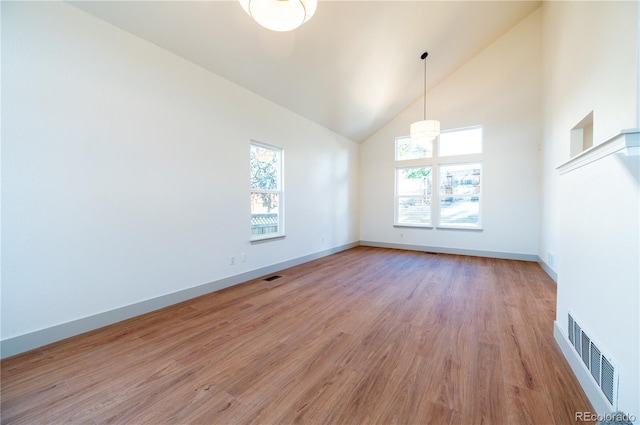 unfurnished room with high vaulted ceiling and light hardwood / wood-style flooring