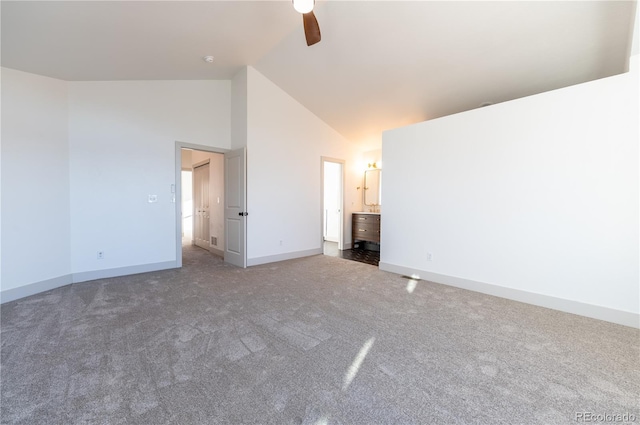 unfurnished bedroom featuring high vaulted ceiling, dark carpet, ceiling fan, and ensuite bathroom