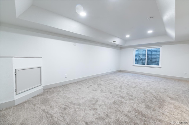 unfurnished room with light carpet and a tray ceiling