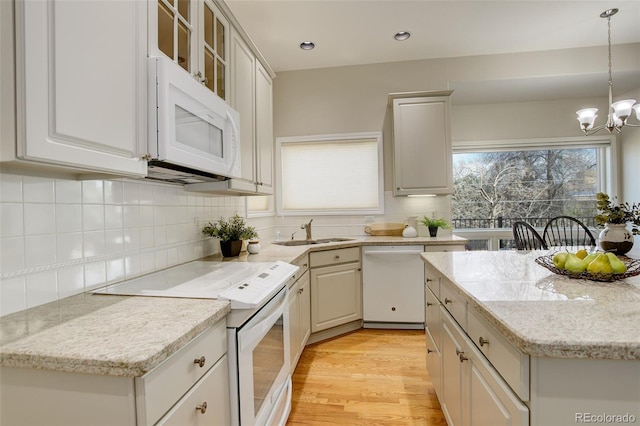 8101 E Dartmouth Ave Unit 22, Denver, CO 80231 - kitchen with white appliances, a sink, a chandelier, decorative light fixtures, and light wood-style flooring
