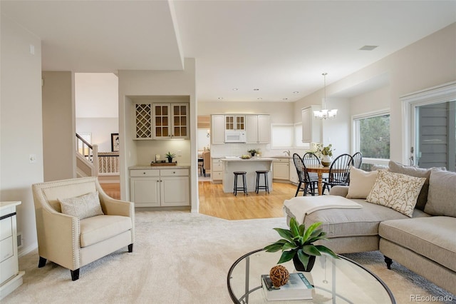 8101 E Dartmouth Ave Unit 22, Denver, CO 80231 - living room featuring a chandelier, light colored carpet, stairs, and recessed lighting