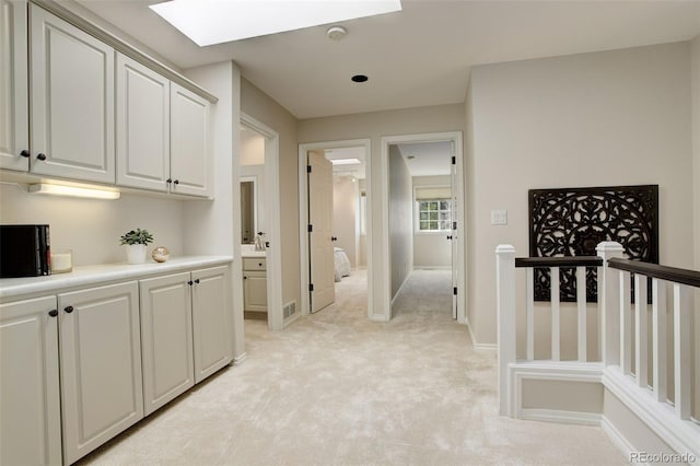 8101 E Dartmouth Ave Unit 22, Denver, CO 80231 - hall with a skylight, light carpet, an upstairs landing, and baseboards