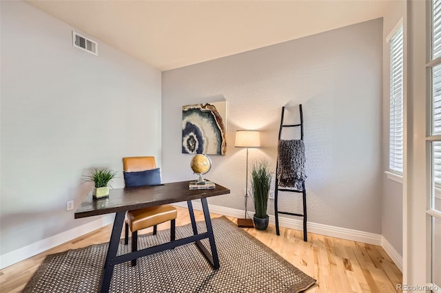 home office with light hardwood / wood-style flooring