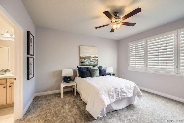 carpeted bedroom with ceiling fan, sink, and ensuite bathroom