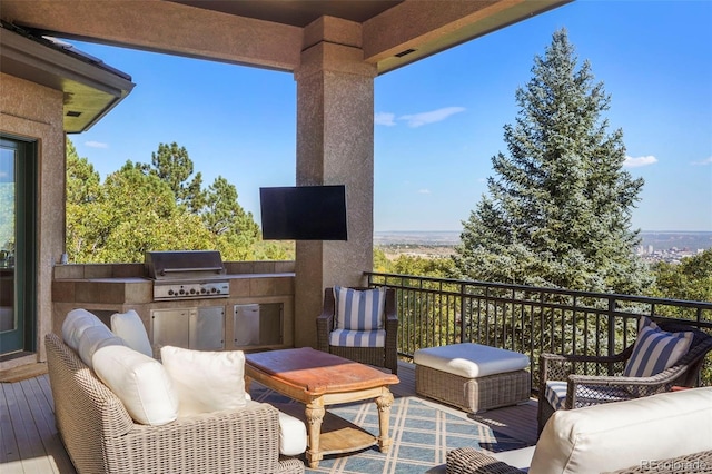 view of patio featuring a grill, a balcony, an outdoor living space, and exterior kitchen