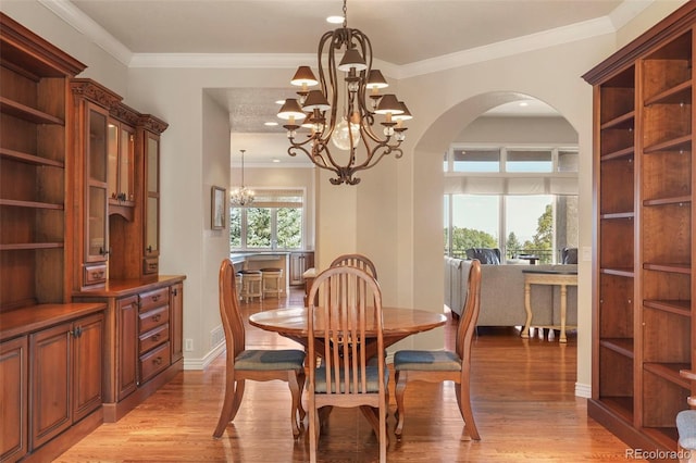 dining space featuring an inviting chandelier, light wood-type flooring, and crown molding