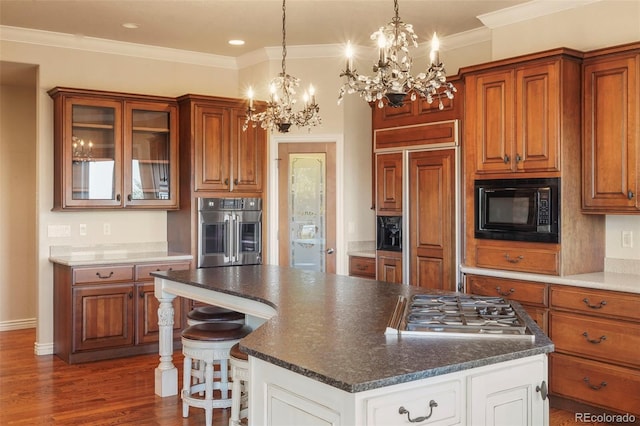 kitchen with white cabinets, built in appliances, crown molding, a kitchen bar, and dark hardwood / wood-style flooring