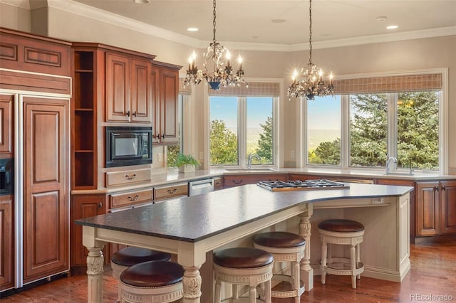 kitchen with appliances with stainless steel finishes, dark hardwood / wood-style flooring, a kitchen breakfast bar, and a kitchen island