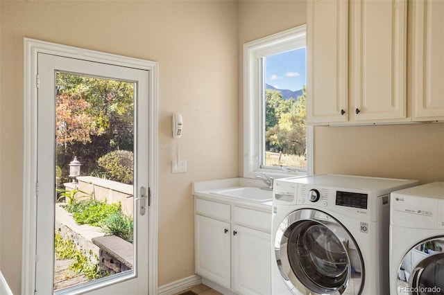 laundry room with cabinets, sink, washing machine and clothes dryer, and a wealth of natural light