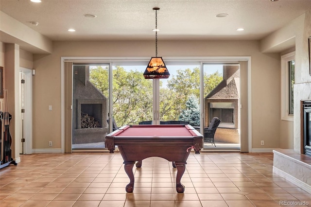 game room featuring a fireplace, plenty of natural light, and light tile patterned floors