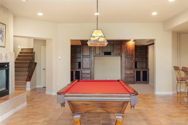 playroom with billiards, light tile patterned floors, and a tiled fireplace