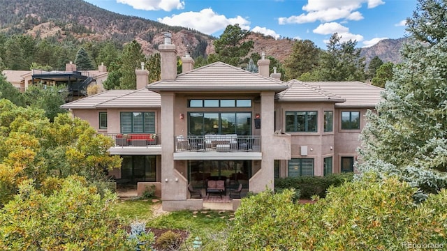 rear view of property featuring a mountain view and a patio