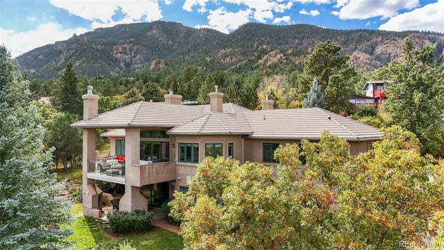 rear view of house featuring a balcony and a mountain view