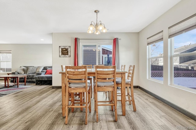 dining room featuring light wood-type flooring and a chandelier