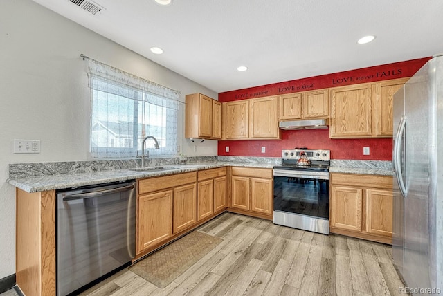 kitchen with light stone countertops, sink, appliances with stainless steel finishes, and light hardwood / wood-style floors