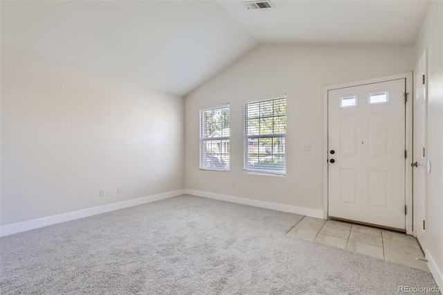 carpeted foyer with vaulted ceiling