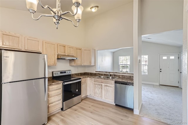 kitchen with light wood-type flooring, high vaulted ceiling, stainless steel appliances, an inviting chandelier, and sink