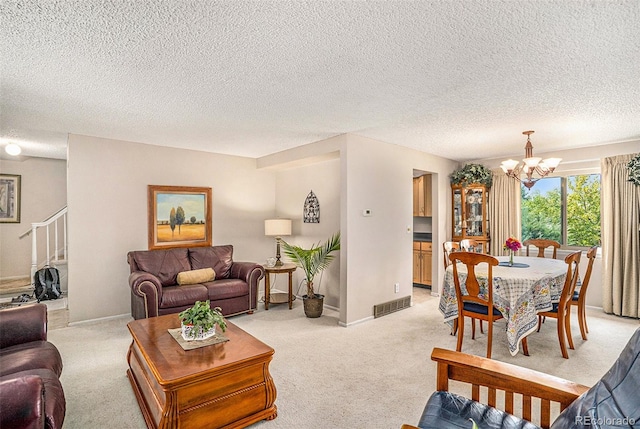 living room with a textured ceiling, light carpet, and a chandelier