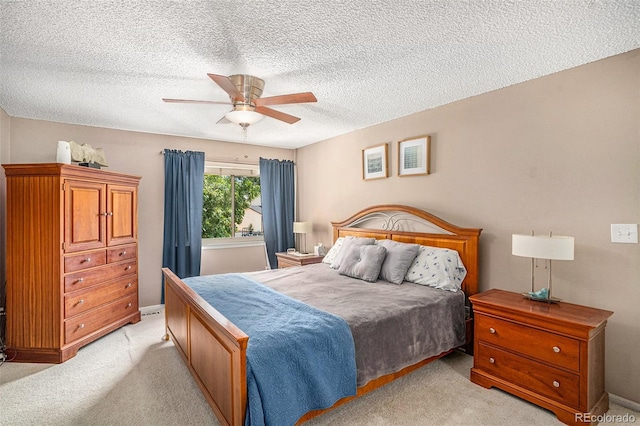 carpeted bedroom with ceiling fan and a textured ceiling