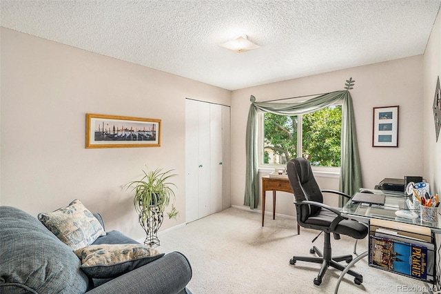 carpeted office space featuring a textured ceiling