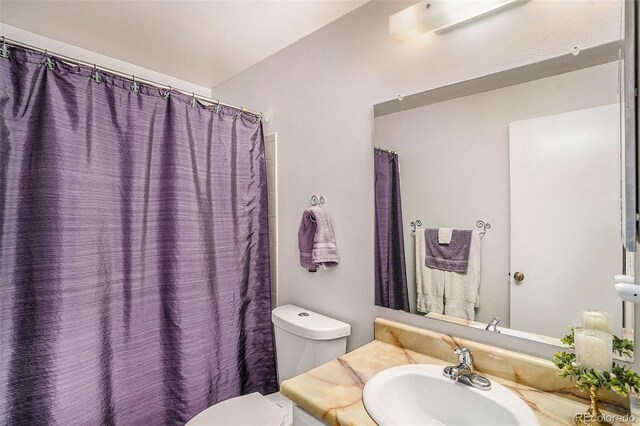 bathroom with toilet, walk in shower, and vanity