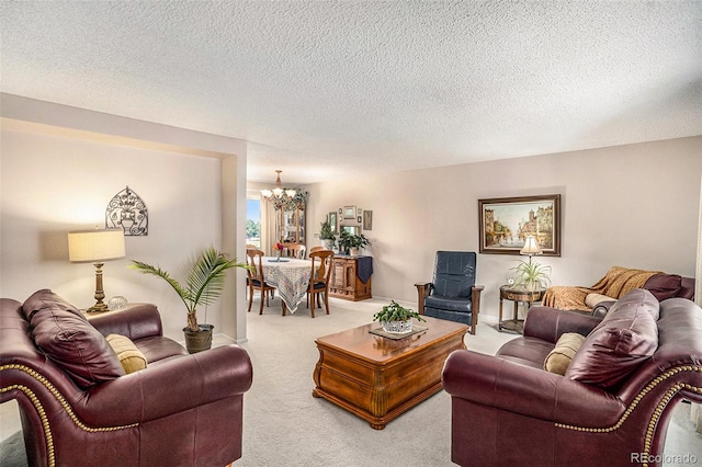 living room with a textured ceiling, a notable chandelier, and carpet flooring