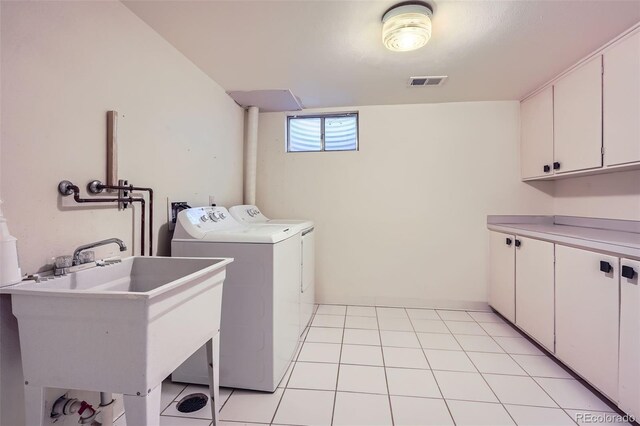 laundry area featuring separate washer and dryer, visible vents, a sink, and cabinet space