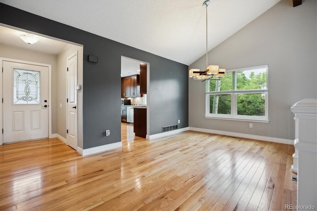 8174 Dudley Cir, Arvada, CO 80005 - unfurnished dining area with a chandelier, light wood finished floors, vaulted ceiling, and baseboards
