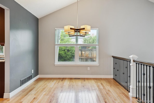 8174 Dudley Cir, Arvada, CO 80005 - spare room featuring a chandelier, wood-type flooring, lofted ceiling, and baseboards