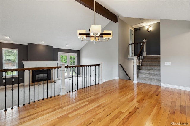 8174 Dudley Cir, Arvada, CO 80005 - unfurnished living room with wood-type flooring, a chandelier, baseboards, a glass covered fireplace, and recessed lighting