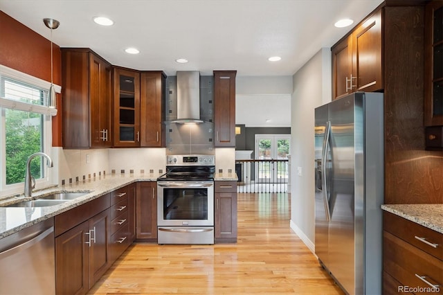 8174 Dudley Cir, Arvada, CO 80005 - kitchen featuring stainless steel appliances, wall chimney exhaust hood, a sink, light wood-style flooring, and healthy amount of natural light