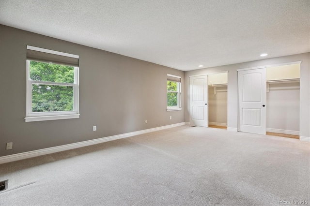 8174 Dudley Cir, Arvada, CO 80005 - unfurnished bedroom with light carpet, multiple closets, recessed lighting, a textured ceiling, and baseboards