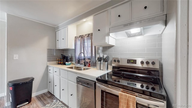 kitchen with sink, stainless steel appliances, tasteful backsplash, white cabinets, and light wood-type flooring