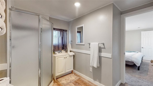 bathroom featuring vanity, hardwood / wood-style floors, and a shower with door